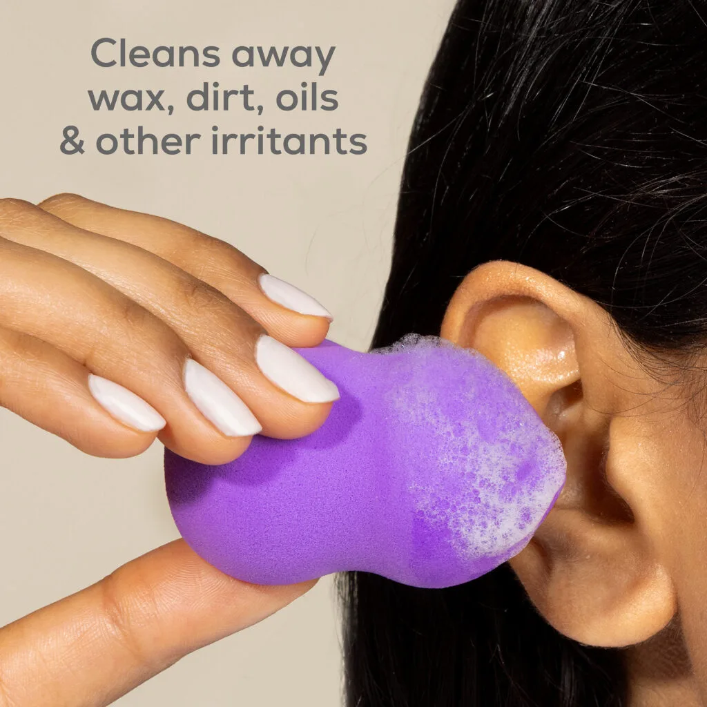 Woman gently cleaning outer ear with Wally's Natural Ear Scrub sponge